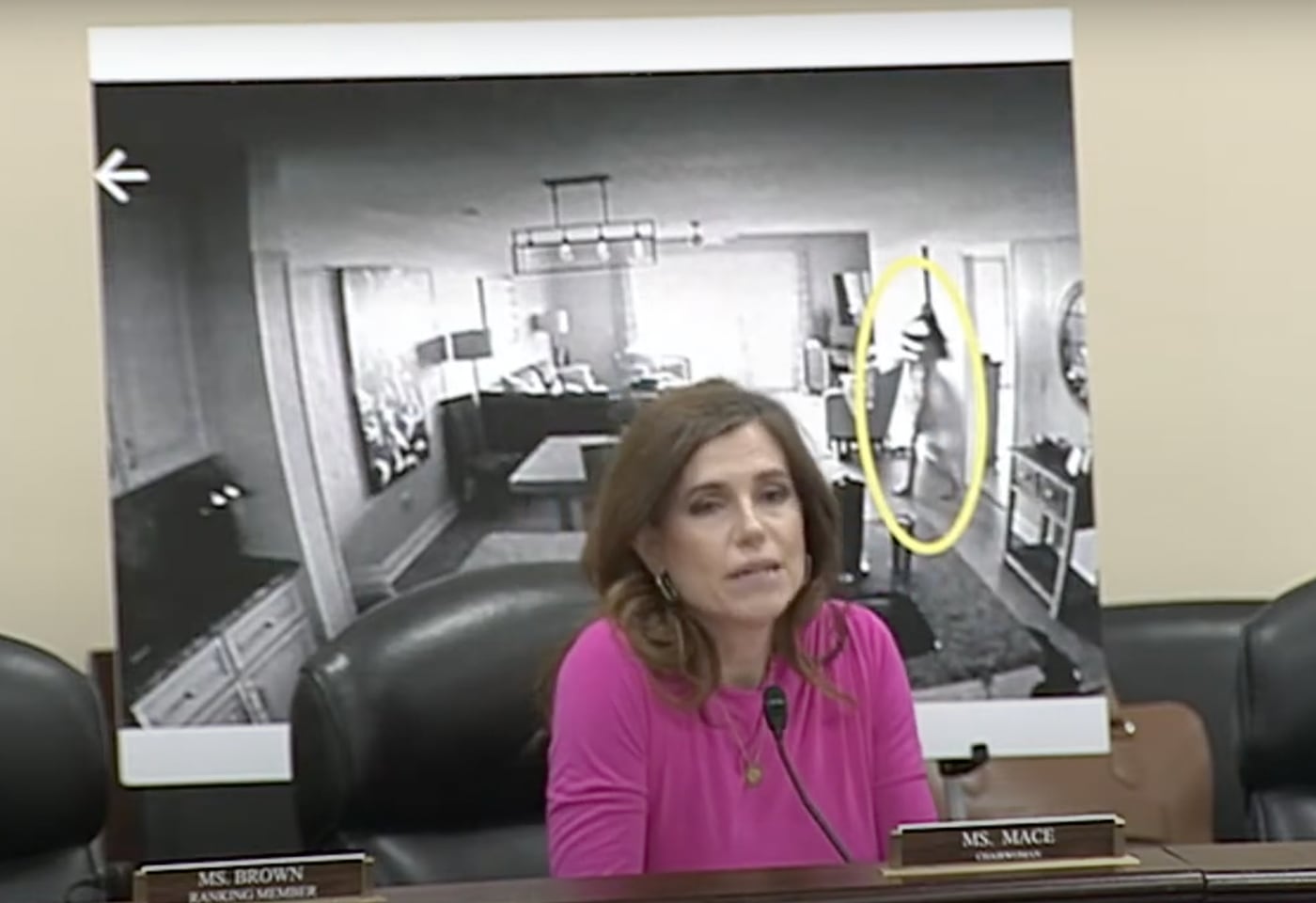 Rep. Nancy Mace at the dais of her House Oversight surveillance hearing, beside a poster-sized surveillance still she said showed her, the figure circled in yellow, May 20, 2025